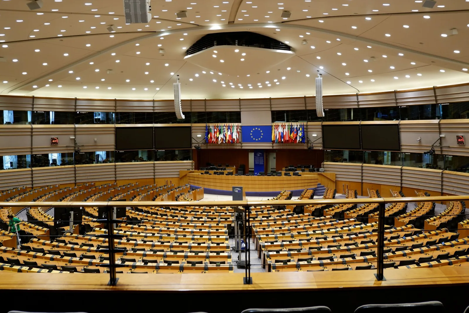 Euroopan parlamentin täysistuntosali tyhjänä, penkkirivit ja sinisiä lippuja