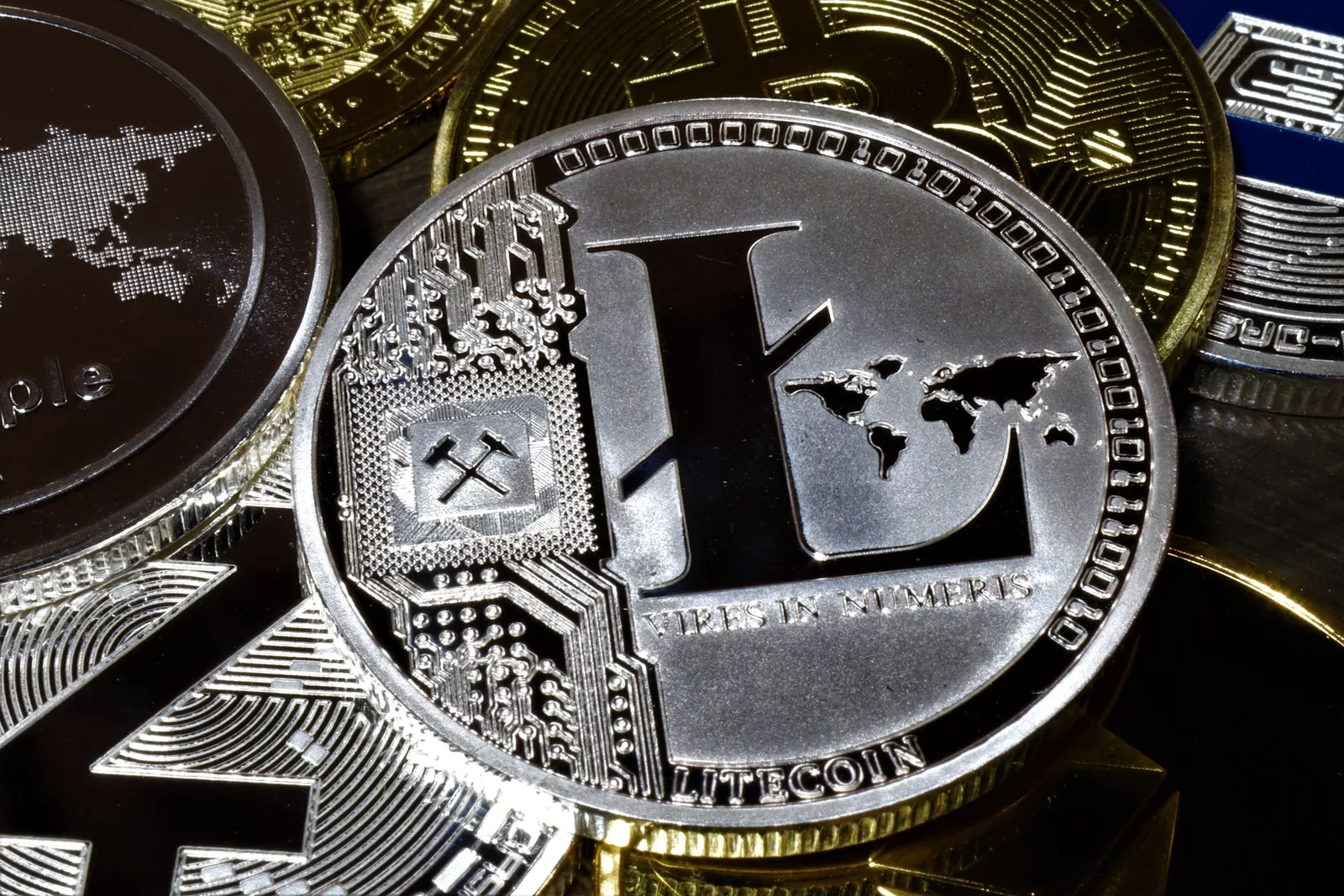 Lähikuva hopeisesta Litecoin-kolikosta muiden kolikoiden päällä