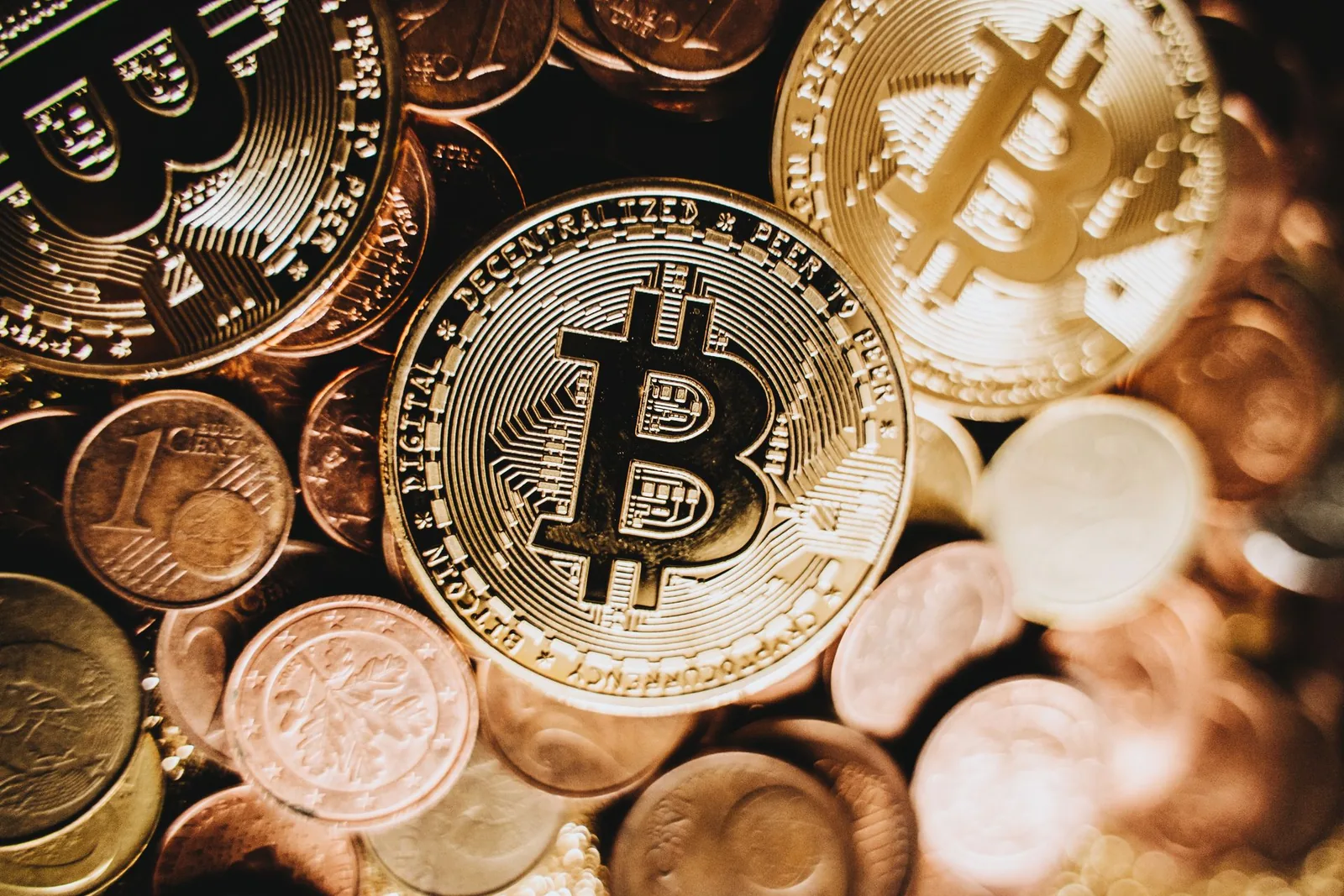 Bitcoin-kolikko lähikuvassa pienempien kolikoiden päällä