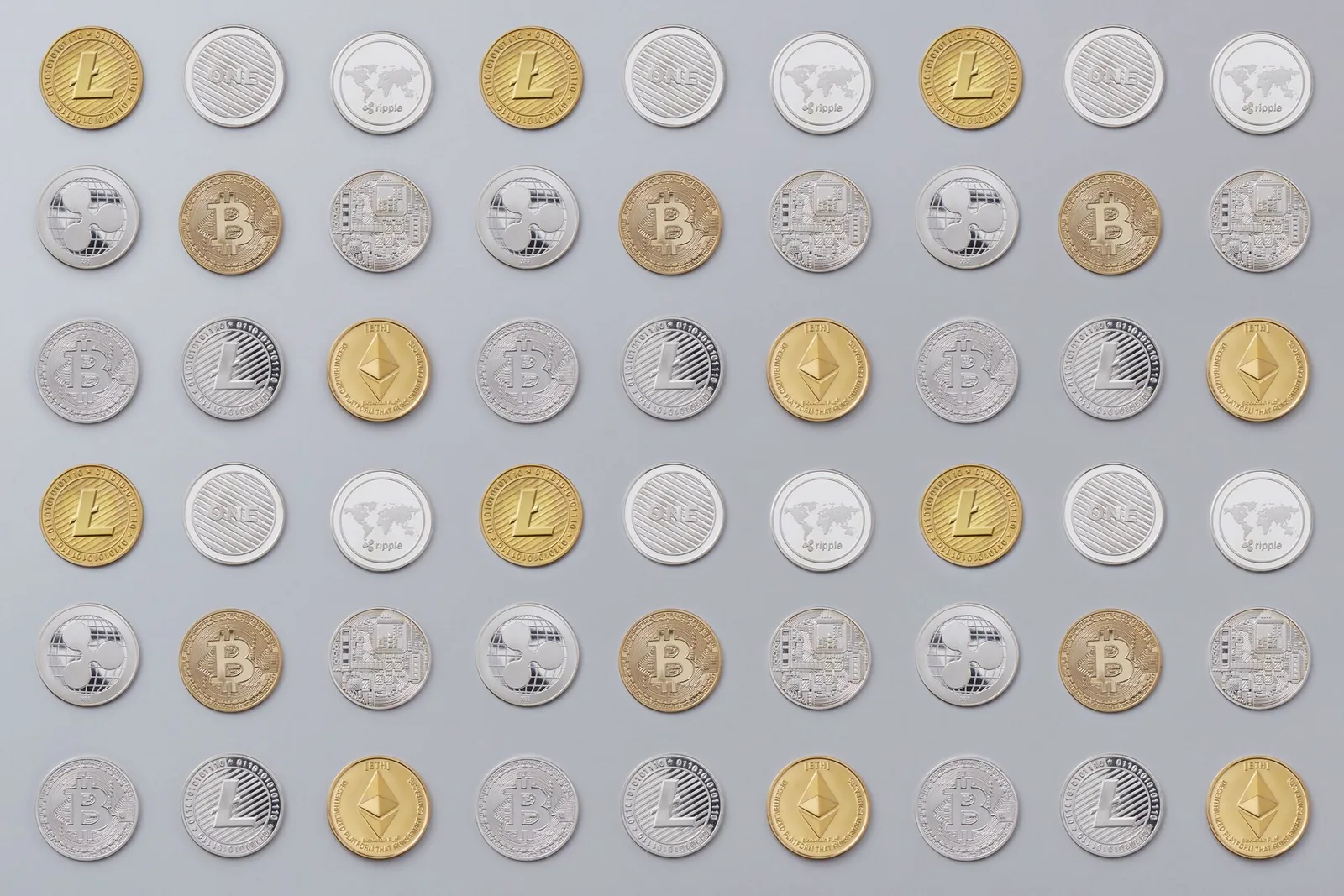 Ruudukko hopea- ja kultaisia kryptokolikoita harmaalla alustalla