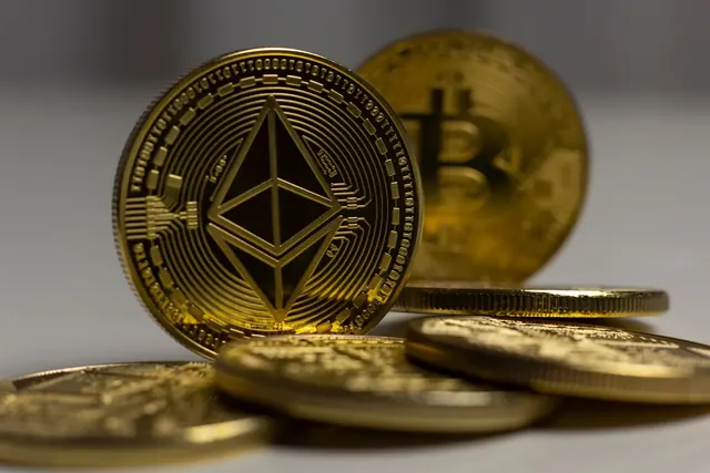 Kultainen Ethereum-kolikko ja bitcoin-kolikko kolikkopinojen vieressä