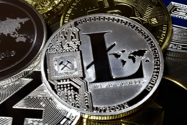 Lähikuva hopeisesta Litecoin-kolikosta muiden kolikoiden päällä