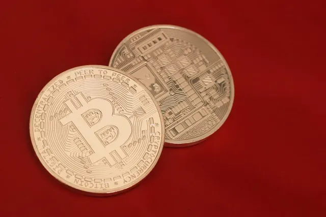 Kaksi bitcoin-kolikkoa punaista taustaa vasten