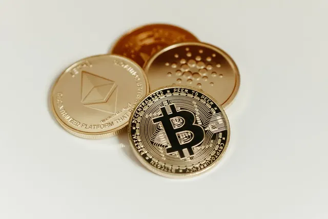 Kolikoita valkoisella alustalla, joukossa Ethereum- ja bitcoin-kolikot