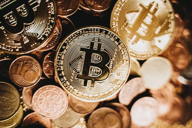 Bitcoin-kolikko lähikuvassa pienempien kolikoiden päällä